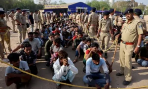 Police officers stand next to men they believe to be undocumented Bangladeshi nationals after they were detained during raids in Ahmedabad, India on April 26, 2025. — Reuters